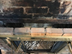 blacked firebox with line of new brick on exterior