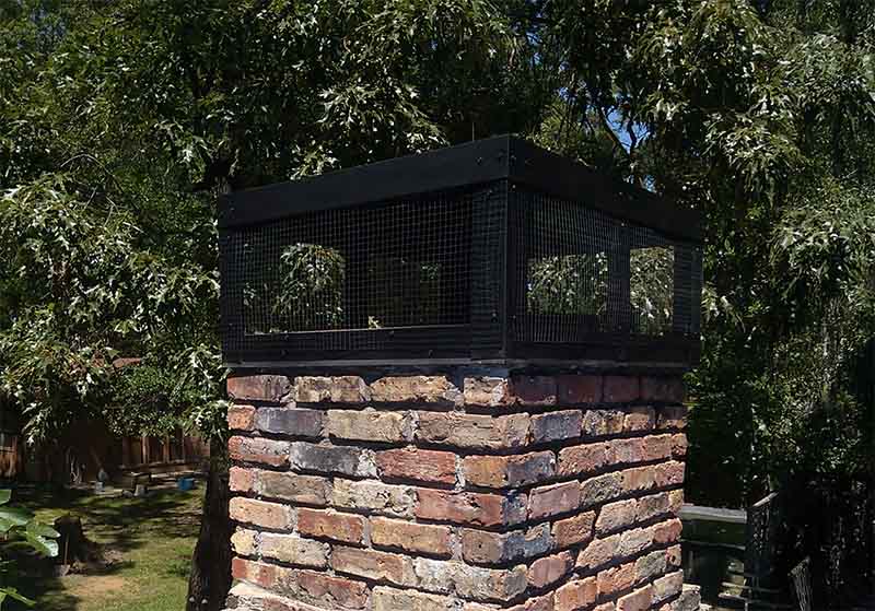black chimney cap on brick chimney